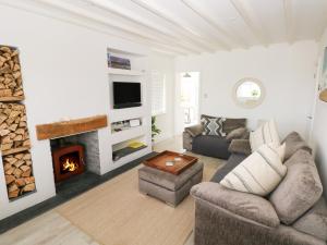 a living room with a couch and a fireplace at 2 Salt Cottage in Swansea