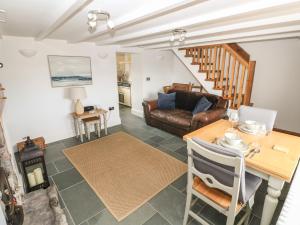 a living room with a table and a couch at 1 Salt Cottage in Swansea