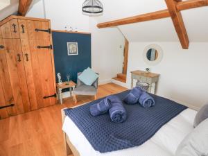 a bedroom with a bed with blue blankets on it at 1 Salt Cottage in Swansea