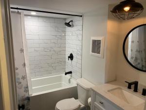 a bathroom with a tub and a toilet and a sink at County Cove - Picton Suite in Wellington