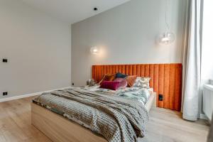 een slaapkamer met een groot bed met een houten hoofdeinde bij Jan III Sobieski - Luksusowy apartament S prywatny darmowy parking in Gliwice