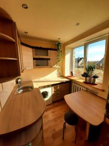 a kitchen with a sink and a table and a window at Dzintaru 97 in Pāvilosta