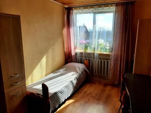 a small bedroom with a window and a bed in front at Dzintaru 97 in Pāvilosta