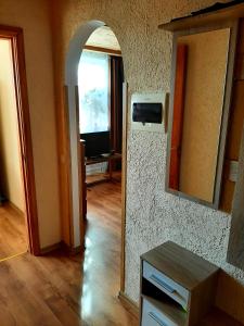 a room with a hallway with a mirror and a television at Dzintaru 97 in Pāvilosta