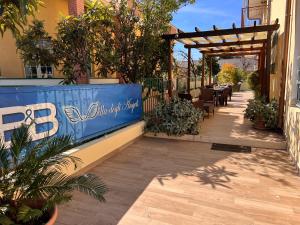 um pátio com uma mesa e uma pérgola em B&B Villa degli Angeli em Praia a Mare