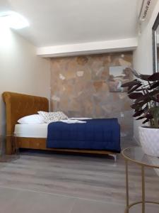 a bedroom with a bed and a stone wall at Guesthouse Casa Bevanda in Međugorje