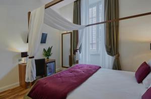 a bedroom with a large bed with a purple blanket at L'obelisque maison de luxe in Rome