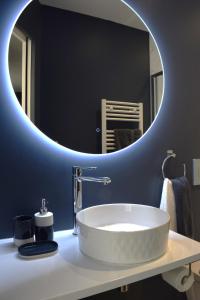 een badkamer met een witte wastafel en een spiegel bij La Bâtie - Terrasse avec Vue imprenable sur le Rhône, 3 chambres, 3 salles de bain in Tain-lʼHermitage