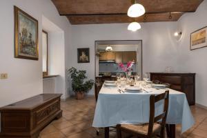 una sala da pranzo con tavolo e panna blu di Enchanting Flat with Patio in Abbadia a Isola a Monteriggioni
