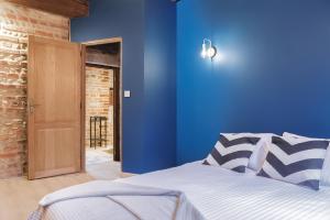 ein Schlafzimmer mit einer blauen Wand und einem Bett in der Unterkunft Renaissance in Bourg-en-Bresse