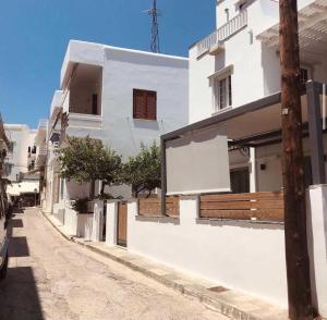 a white building with a sign on the side of a street at Ambrosia in Tinos