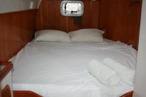 a bed with two pillows and towels on it at On Y Va , Delightful 3 bedroom catarmaran, with skipper in Marmaris