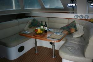 a table with a couch and a table with two bottles of wine at On Y Va , Delightful 3 bedroom catarmaran, with skipper in Marmaris