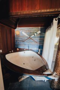 a bath tub in a room with a clock on the wall at Pousada Café Zapata in Amontada