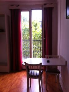 パリにあるグラン ホテル マジェンタの窓際のテーブルと椅子2脚