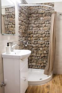 a bathroom with a sink and a stone wall at Paradise of Meteora A in Kastrákion