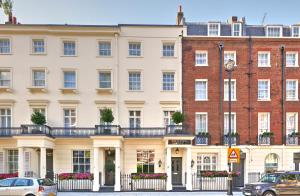 a large white building with cars parked in front of it at The Tophams Hotel in London