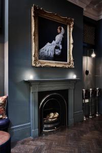 a fireplace with a painting on the wall at The Tophams Hotel in London