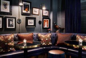 a living room with a couch and two tables at The Tophams Hotel in London