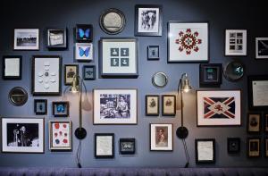 a wall with a bunch of pictures on it at The Tophams Hotel in London