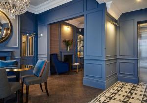 a room with blue walls and a table and chairs at The Tophams Hotel in London
