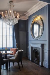 a living room with a chandelier and a fireplace at The Tophams Hotel in London