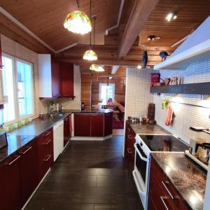 a large kitchen with wooden ceilings and wooden cabinets at Rysseli in Kiuruvesi