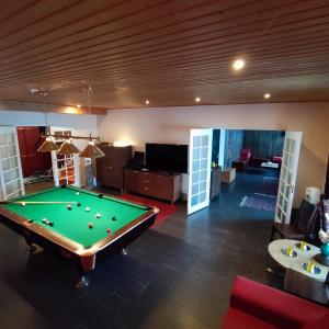 a room with a pool table and a living room at Rysseli in Kiuruvesi