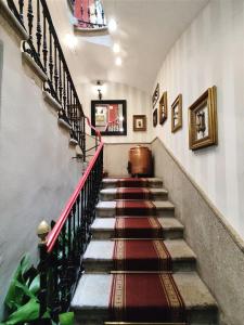 a staircase in a building with a red railing at Hotel Iberia Plaza Mayor in Cáceres