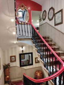 a staircase leading up to a balcony with a clock on it at Hotel Iberia Plaza Mayor in Cáceres