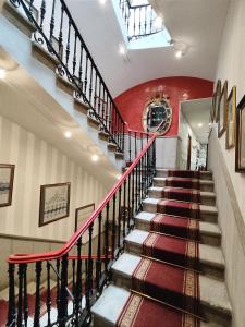 a staircase in a building with a red wall at Hotel Iberia Plaza Mayor in Cáceres