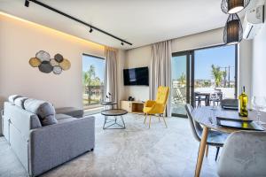 uma sala de estar com um sofá e uma mesa em Pathos SeaSide Suites em Faliraki