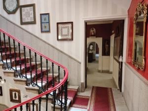 a stairway leading up to a large room with red walls at Hotel Iberia Plaza Mayor in Cáceres
