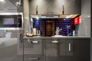 a kitchen with a refrigerator and a counter top at Roomzzz Nottingham City in Nottingham