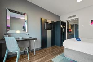a hotel room with a large mirror and a television at Roomzzz Nottingham City in Nottingham