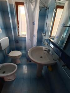 a bathroom with a sink and a toilet and a mirror at Il Paradiso degli Dei in Milazzo