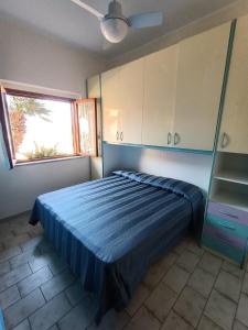 a bedroom with a blue bed and a window at Il Paradiso degli Dei in Milazzo