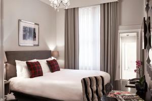فندق ذا توفامس في لندن: غرفة نوم مع سرير أبيض كبير مع وسائد حمراء