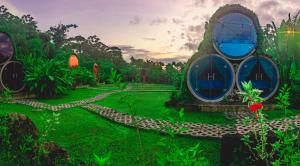 a garden with a house in the grass at Arenal Backpackers Resort in Fortuna