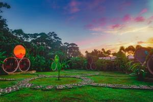 un jardin avec un chemin en pierre dans la pelouse dans l'établissement Arenal Backpackers Resort, à Fortuna