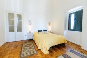 Dormitorio blanco con cama y ventana grande en Pinheiro de Monsaraz -Casas Santo António T2, en Reguengos de Monsaraz