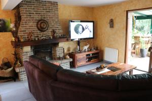 a living room with a couch and a tv at PAVILLON TOUT CONFORT EN CAMPAGNE in Vred