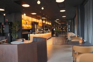 a restaurant with tables and chairs and a bar at Clarion Collection Hotel Kongsberg in Kongsberg