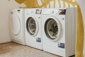 três máquinas de lavar estão sentadas ao lado uma da outra em Party Hostel Zzz em Liubliana