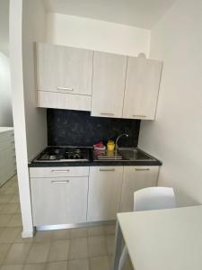 a white kitchen with a stove and a sink at Solemare Federica in Lignano Sabbiadoro