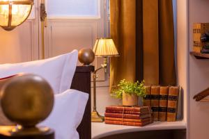 sypialnia z łóżkiem, lampką i książkami w obiekcie Maison Cardinal Furstemberg w Paryżu