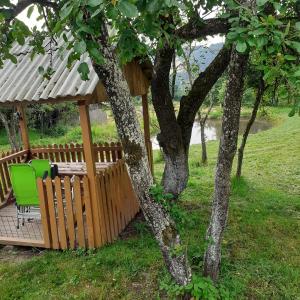 un cenador con mesa y sillas junto a un árbol en RETREAT COZY FARMHOUSE SEJOUR Roşia Montana, Acces Optional Hottube en Roşia Montană