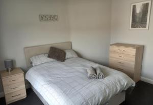 um quarto com uma cama com dois chinelos em Springfield Gardens - Ilkeston - Close to M1-A52 Long Eaton - Nottingham - Derbyshire - 500Mbs WiFi! em Ilkeston