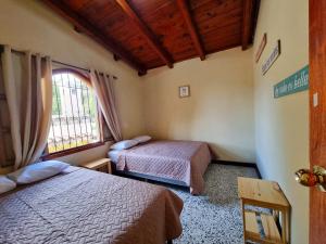 1 dormitorio con 2 camas y ventana en Central Hostel, en Antigua Guatemala