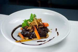 a white plate of food with carrots and meat at Hotel Das Zeit in Lenzing